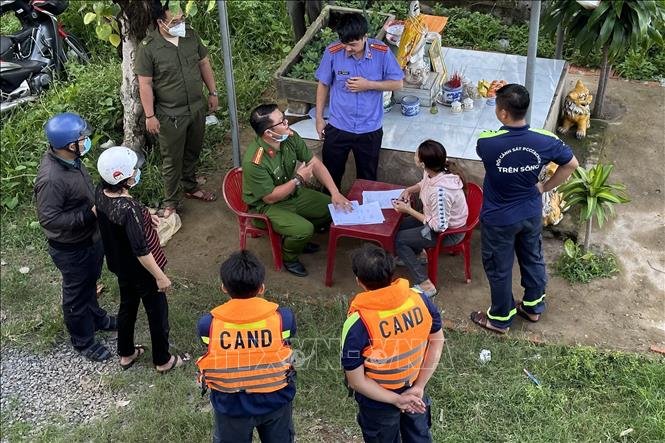 Lực lượng chức năng tỉnh Đồng Nai bàn giao thi thể bé gái bị nước cuốn cho gia đình. Ảnh: Lê Xuân-TTXVN