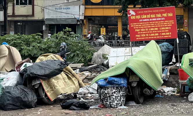 Rác thải đổ bừa bãi dù có biển cấm đổ rác tại phố Trịnh Đình Cửu, phường Định Công (Hoàng Mai). Ảnh: Phương Anh-TTXVN