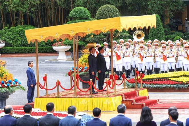 Chủ tịch nước Lương Cường và Tổng thống Pháp Emmanuel Macron nghe quân nhạc cử Quốc thiều hai nước. Ảnh: Tuấn Anh – TTXVN