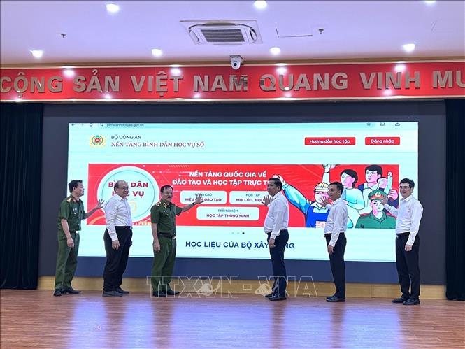 Bộ trưởng Bộ Xây dựng Trần Hồng Minh, Thứ trưởng Bộ Công an Nguyễn Văn Long và các đại biểu tiến hành nghi thức ra mắt trang thông tin Bình dân học vụ số Bộ Xây dựng. Ảnh: Diệp Anh - TTXVN