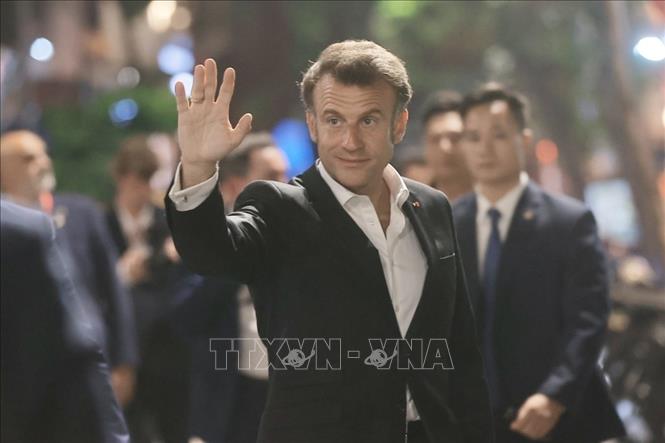 Tổng thống Pháp Emmanuel Macron vẫy chào người dân Thủ đô. Ảnh: TTXVN