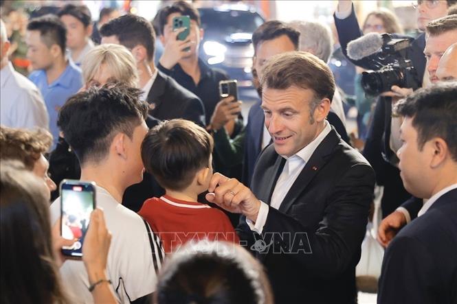 French President Emmanuel Macron and his first lady meet local people while strolling through Hanoi's Old Quarter in the evening of May 26. Photo: VNA