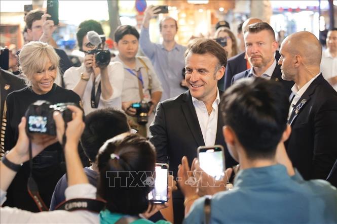 French President Emmanuel Macron and his first lady meet local people while strolling through Hanoi's Old Quarter in the evening of May 26. Photo: VNA