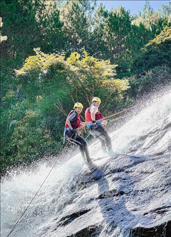 Du khách trải nghiệm vượt thác trong Conyoning tour. Ảnh: TTXVN phát