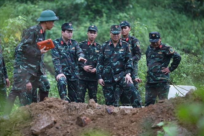 Thượng tá Bùi Văn Mai, Phó Chỉ huy trưởng kiêm Tham mưu trưởng Bộ CHQS tỉnh Hòa Bình (thứ hai, bên phải) cùng cán bộ chiến sĩ kiểm tra an toàn tại điểm hủy nổ. Ảnh: Trọng Đạt - TTXVN