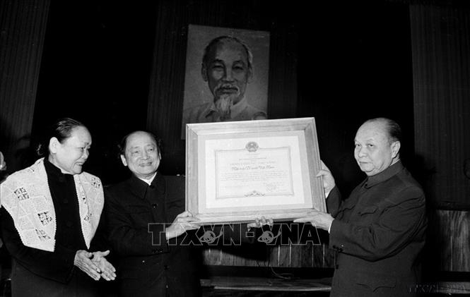 Đồng chí Trường Chinh, Chủ tịch Uỷ ban Thường vụ Quốc hội trao tặng Huân chương Sao Vàng cho Chủ tịch Đoàn Chủ tịch UBTƯ MTTQ Việt Nam Hoàng Quốc Việt (Hà Nội, 8/12/1980). Ảnh: Ngọc Khanh - TTXVN