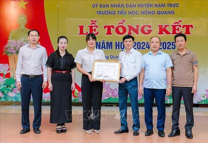 Sở Giáo dục và Đào tạo tỉnh Nam Định trao tặng Giấy khen cho cô giáo Nguyễn Thị Mai vì có hành động dũng cảm cứu người. Ảnh: Công Luật - TTXVN