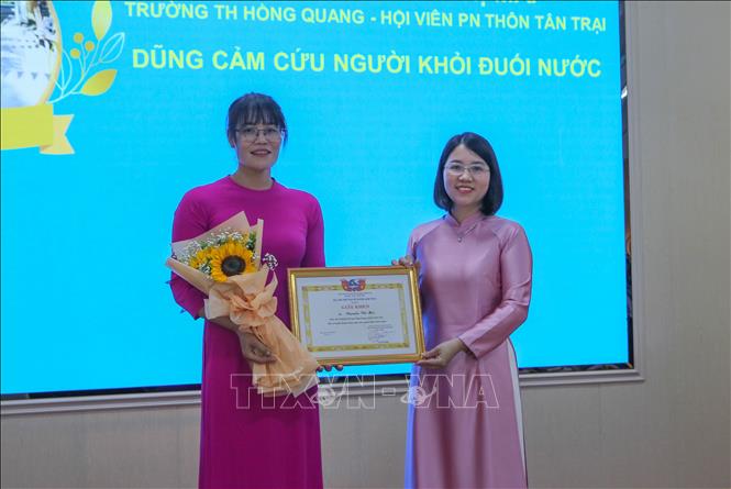 Hội Liên hiệp Phụ nữ Việt Nam huyện Nam Trực, tỉnh Nam Định trao tặng Giấy khen cho cô giáo Nguyễn Thị Mai vì có hành động dũng cảm cứu người. Ảnh: Công Luật - TTXVN