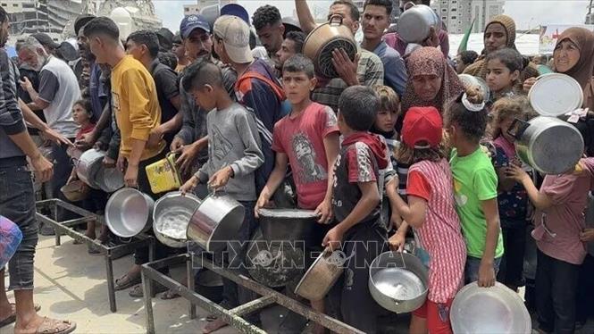 Người dân Palestine nhận thức ăn cứu trợ tại Dải Gaza. Ảnh: IRNA/TTXVN