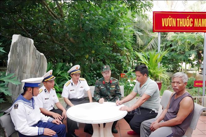 Ngư dân Võ Tấn Nước (ngoài cùng, bên phải) tại thời điểm bàn giao cho đại diện tàu cá BĐ 98967 TS. Ảnh: TTXVN phát