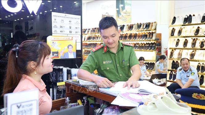 Đội QLTT cơ động số 9 phối hợp với Phòng Cảnh sát kinh tế, Công an tỉnh Thanh Hóa kiểm tra hàng hóa bày bán tại cửa hàng Tùng Moscow. Ảnh: Đội QLTT số 9/TTXVN phát
