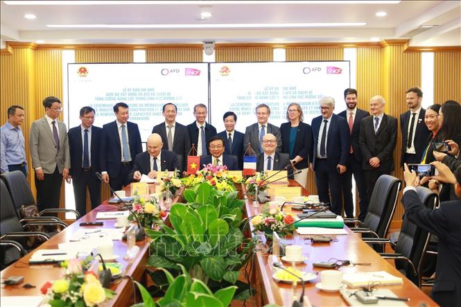 Deputy Minister Huy, AFD Director General Rioux, and SNCF International President Diego Diaz sign a memorandum of understanding between the Ministry of Construction, AFD, and SNCF International on enhancing the capacity of ministry officials in the railway sector. VNA Photo: Diệp Anh