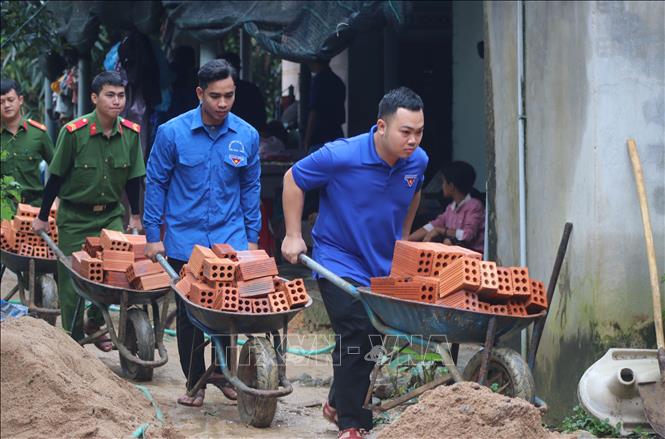 Lực lượng đoàn viên thanh niên, công an góp công vận chuyển vật liệu để xây dựng nhà cho người dân trong chương trình xóa nhà tạm, nhà dột nát ở Quảng Ngãi. Ảnh: Phạm Cường - TTXVN