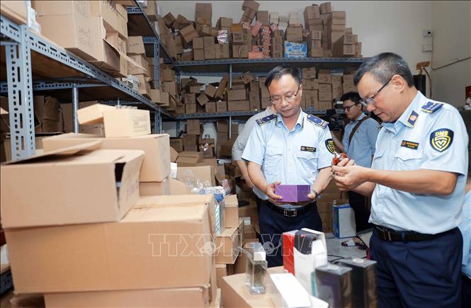 Lực lượng chức năng kiểm tra nhãn mác, thống kê số lượng tại kho hàng. Ảnh: Trần Việt - TTXVN
