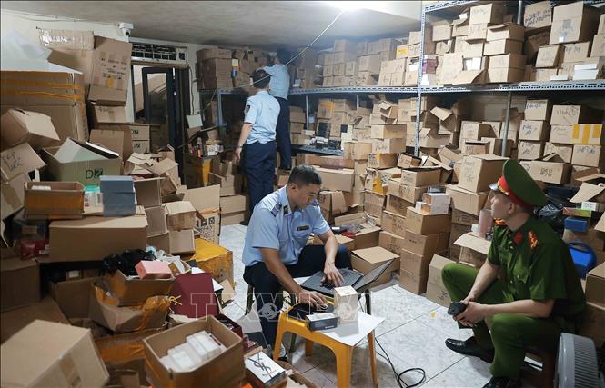 Lực lượng chức năng kiểm tra, thống kê số lượng tại kho hàng. Ảnh: Trần Việt - TTXVN
