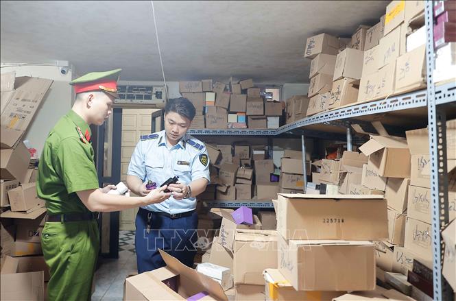 Lực lượng chức năng kiểm tra nhãn mác, thống kê số lượng tại kho hàng. Ảnh: Trần Việt - TTXVN
