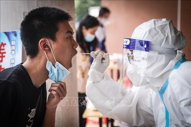Nhân viên y tế lấy mẫu xét nghiệm COVID-19 cho người dân tại tỉnh Liêu Ninh, Trung Quốc. Ảnh: THX/TTXVN