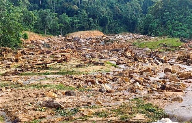 Đất đá nằm ngổn ngang dưới lòng khe Phùng khi lũ quét càn qua. Ảnh: TTXVN phát 