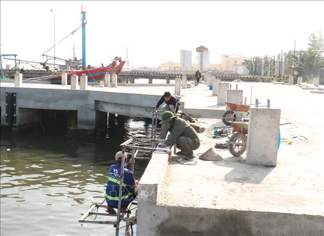 Công nhân lắp đặt thiết bị tại bến cảng của cảng cá Nam Cửa Việt, huyện Triệu Phong (Quảng Trị). Ảnh: Nguyên Lý - TTXVN