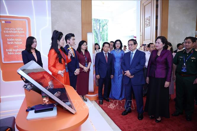 Thủ tướng Phạm Minh Chính tham quan trưng bày sản phẩm dịch vụ, ứng dụng chuyển đổi số trong hoạt động ngân hàng. Ảnh: Dương Giang-TTXVN
