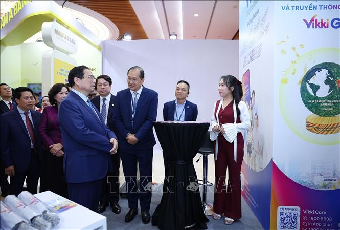 Thủ tướng Phạm Minh Chính tham quan trưng bày sản phẩm dịch vụ, ứng dụng chuyển đổi số trong hoạt động ngân hàng. Ảnh: Dương Giang-TTXVN
