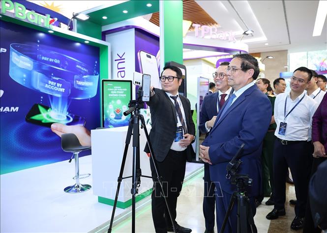 Thủ tướng Phạm Minh Chính tham quan trưng bày sản phẩm dịch vụ, ứng dụng chuyển đổi số trong hoạt động ngân hàng. Ảnh: Dương Giang-TTXVN
