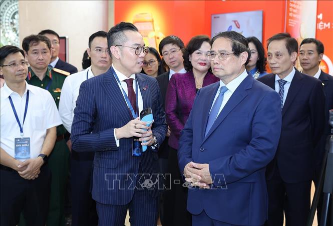 Thủ tướng Phạm Minh Chính tham quan trưng bày sản phẩm dịch vụ, ứng dụng chuyển đổi số trong hoạt động ngân hàng. Ảnh: Dương Giang-TTXVN
