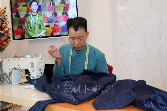 Craft of making ao dai is introduced at the exhibition. VNA Photo: Văn Đức 