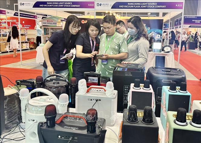 Visitors experience using products displayed in the exhibition. VNA Photo: Mỹ Phương