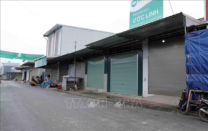 Hàng loạt cửa hàng dọc chợ Thổ Tang cửa đóng then cài. Ảnh: Hoàng Hùng - TTXVN