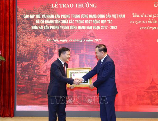 Đồng chí Thongsalith Mangnomek, Bí thư Trung ương Đảng, Chánh Văn phòng Trung ương Đảng Nhân dân Cách mạng Lào trao Huân chương Tự do hạng Ba của Lào cho đồng chí Bùi Văn Thạch, nguyên Phó Chánh Văn phòng Trung ương Đảng. Ảnh: Phương Hoa – TTXVN