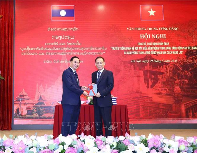 Đồng chí Lê Hoài Trung, Bí thư Trung ương Đảng, Chánh Văn phòng Trung ương Đảng tặng sách cho đồng chí đồng chí Thongsalith Mangnomek, Bí thư Trung ương Đảng, Chánh Văn phòng Trung ương Đảng Nhân dân Cách mạng Lào. Ảnh: Phương Hoa – TTXVN