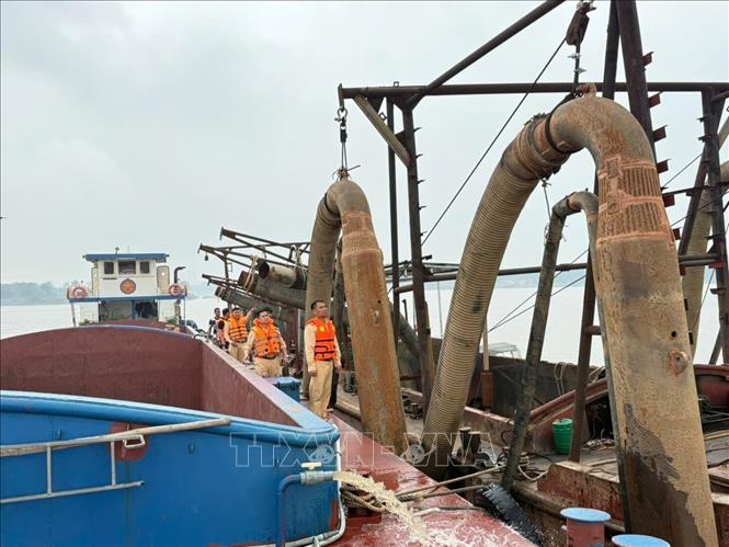 Phương tiện hút cát trái phép trên sông Hồng bị lực lượng chức năng bắt giữ. Ảnh: TTXVN phát