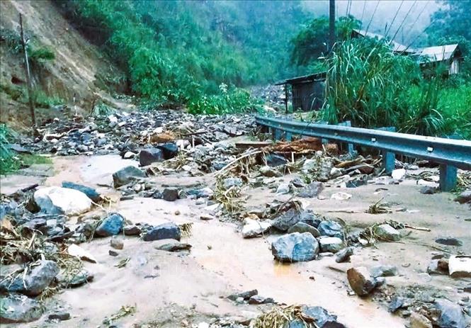 Lượng lớn đất đá, cây rừng đổ xuống gây tắc đường trên quốc lộ 16 tại km304 +600. Ảnh: TTXVN phát 