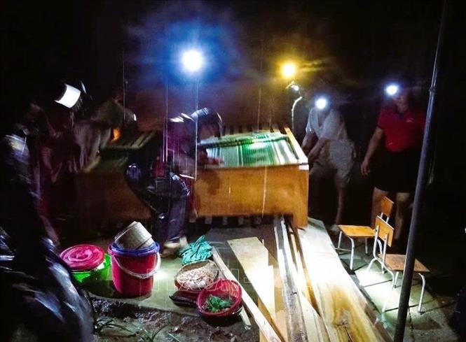 Lực lượng chức năng giúp người dân xã Nhôn Mai (Tương Dương, Nghệ An) sơ tán, di chuyển đồ đạc chạy lũ trong đêm 29/5. Ảnh: TTXVN phát 
