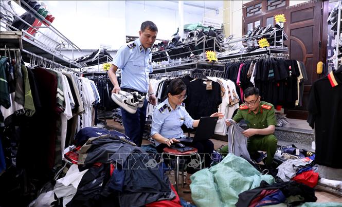 Lực lượng quản lý thị trường tỉnh Tuyên Quang kiểm tra, lập biên bản một cửa hàng kinh doanh quần áo có dấu hiệu giả mạo nhãn hiệu tại phường Minh Xuân, thành phố Tuyên Quang. Ảnh: Quang Cường - TTXVN
