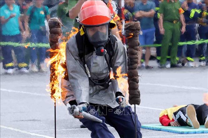 Các đội tuyển thi đấu môn thi 4x100m chạy tiếp sức cứu người và chữa cháy. Ảnh: Phạm Kiên - TTXVN