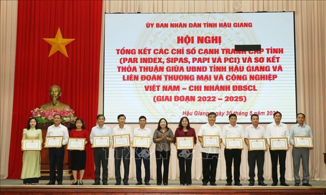 Trao tặng Bằng khen của Chủ tịch UBND tỉnh Hậu Giang cho các cá nhân, tập thể có nhiều đóng góp trong thực hiện các chỉ số canh tranh cấp tỉnh. Ảnh: Duy Khương - TTXVN