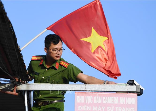 Thiếu tá Hồ Kiên Trung, Trưởng Công an xã Văn Hải, huyện Quỳnh Lưu kiểm tra, bảo dưỡng camera an ninh phòng chống tội phạm được lắp đặt tại các xóm trong xã. Ảnh: Trọng Đức - TTXVN
