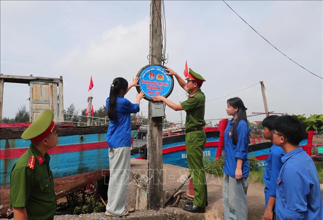 Lực lượng công an và thanh niên xã Văn Hải triển khai lắp đặt pa nô, áp phích tuyên truyền phòng chống ma túy tại các thôn, xóm. Ảnh: Trọng Đức - TTXVN