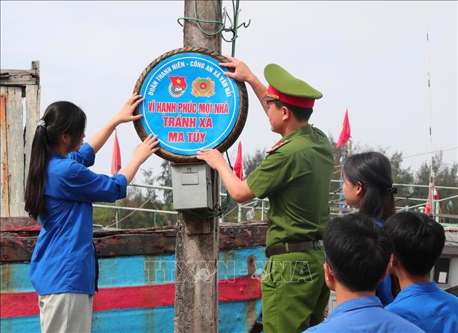Lực lượng Công an và thanh niên xã Văn Hải triển khai lắp đặt pa nô, áp phích tuyên truyền phòng chống ma túy tại các thôn, xóm. Ảnh: Trọng Đức - TTXVN
