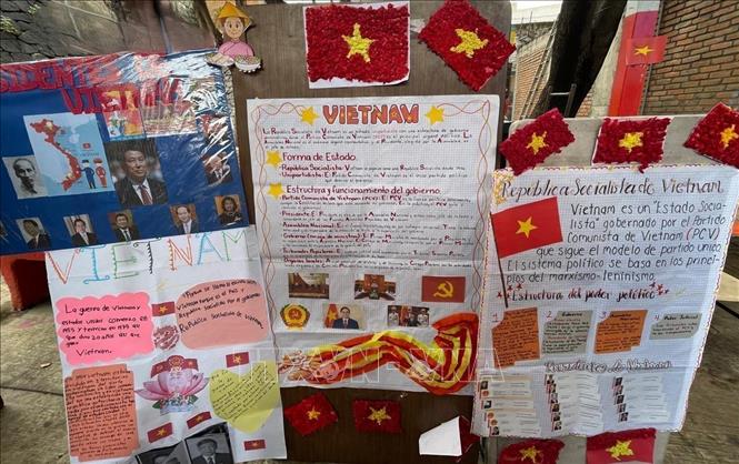 Học sinh viết báo tường về Việt Nam tại lễ kỷ niệm 50 năm Quan hệ Việt Nam - Mexico trong khuôn viên trường. Ảnh: TTXVN phát

