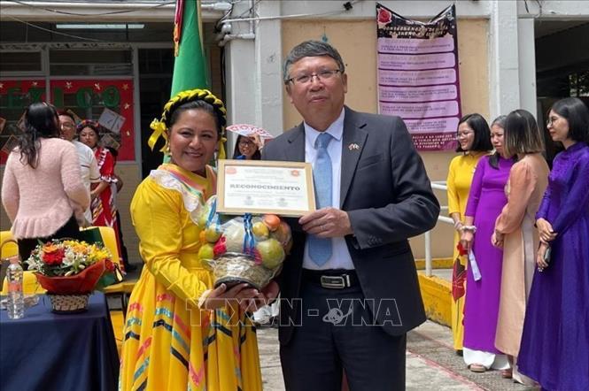 Bà Marisol Nolasco Najera, Hiệu trưởng Trường CHXHCN Việt Nam tặng Kỷ niệm chương cho Đại sứ Nguyễn Văn Hải. Ảnh: TTXVN phát
