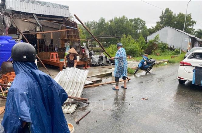 Lực lượng Công an và bảo vệ an ninh trật tự cơ sở xã Nam Yên, huyện An Biên (Kiên Giang) giúp dân khắc phục hậu quả sau lốc xoáy. Ảnh: TTXVN phát