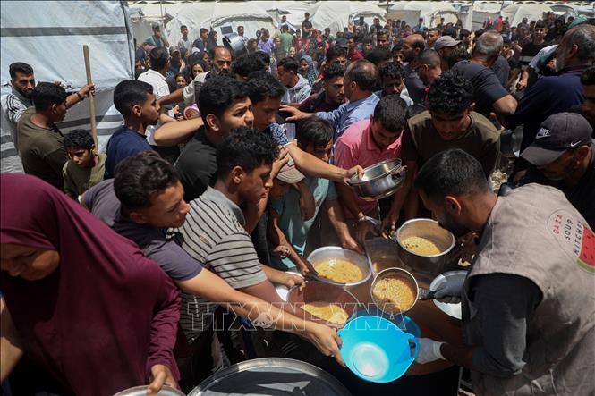 Người dân Palestine nhận thức ăn cứu trợ tại thành phố Gaza ngày 28/5/2025. Ảnh: THX/TTXVN