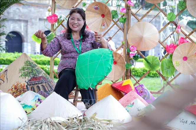 Nghệ nhân Tạ Thu Hương trực tiếp làm nón lá tại Lễ hội Du lịch Hà Nội 2025. Ảnh: Khánh Hoà - TTXVN
