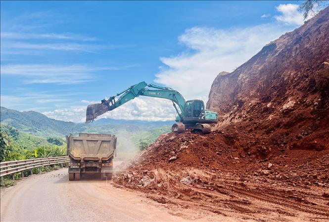 Thi công sửa chữa mặt đường hẹp khắc phục tình trang mất an toàn giao thông ở Quốc lộ 15D. Ảnh: Nguyên Linh-TTXVN