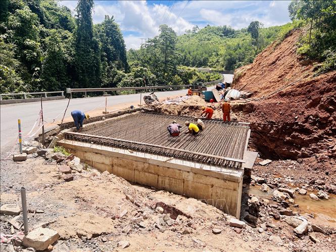 Thi công sửa chữa mặt đường, nền đường, mặt đường hẹp nhằm khắc phục tình trang mất an toàn giao thông ở Quốc lộ 15D. Ảnh: Nguyên Linh-TTXVN
