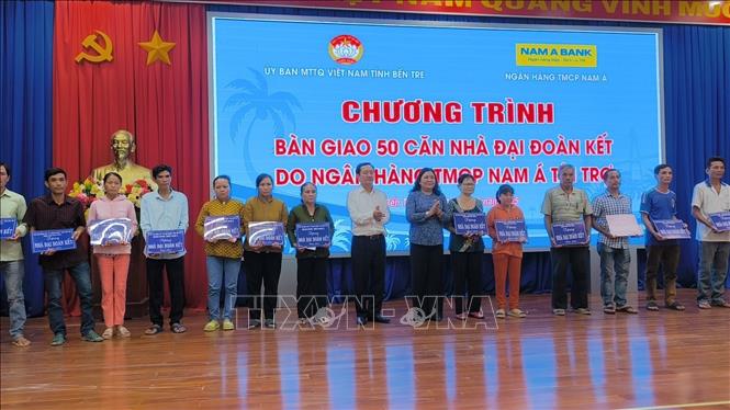 Trao bảng tượng trưng và quà cho người dân được nhận nhà mới. Ảnh: Huỳnh Phúc Hậu - TTXVN