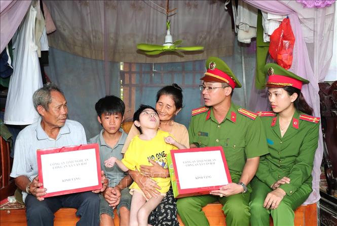 Cán bộ Công an xã thăm hỏi, động viên và trao quà hỗ trợ cho gia đình có hoàn cảnh khó khăn trên địa bàn. Ảnh: Trọng Đức - TTXVN